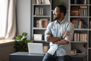 African businessman looking out the window dreaming about future