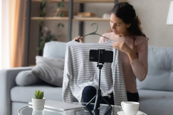 Mujer vlogger disparando vídeo de revisión de ropa en el teléfono inteligente en casa — Foto de Stock