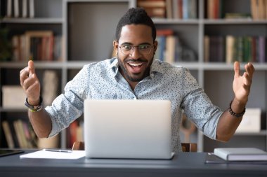 African guy looking at pc screen feels shocked