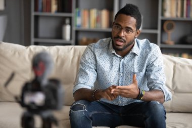 African guy filming online training webinar using camcorder