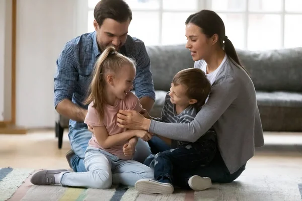 Happy young family playing on warm floor in living room — Stock Photo, Image