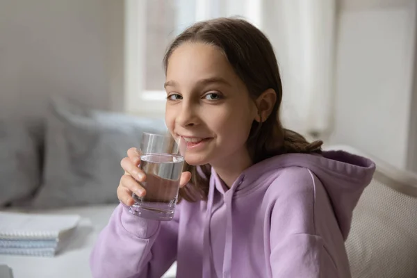 Retrato de una adolescente sonriente bebiendo agua mineral —  Fotos de Stock