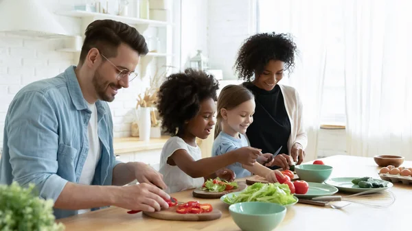 Full multinational family preparing dietary vegetable salad in kitchen — Stock Photo, Image