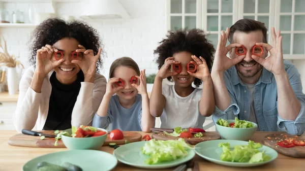 Family cooking together having fun covering eyes with red paprika — Stok fotoğraf