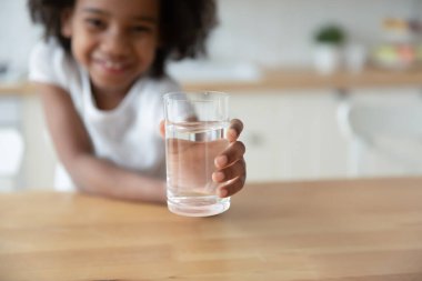 African girl holds out hand glass of water closeup image