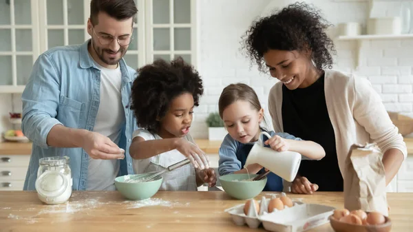 Full multi ethnic family cooking pancakes together in modern kitchen — Stok fotoğraf