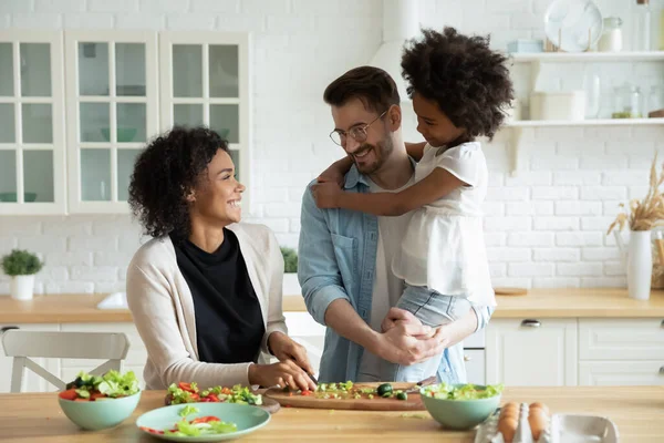 Esposa africana preparando la cena y charlando con la hija y el marido —  Fotos de Stock