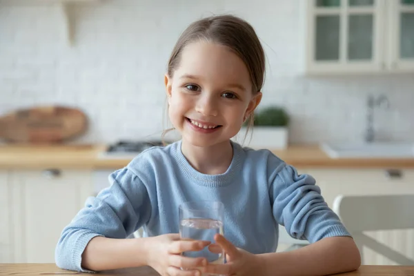 Retrato de la cabeza niña sosteniendo un vaso de agua quieta —  Fotos de Stock