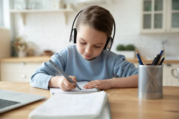 Girl in headphones learning at home doing homework using laptop — Stock Photo, Image