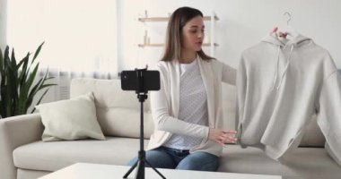 Pretty young female blogger sharing shopping experience with followers.