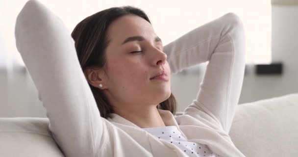 Mujer atractiva refrescante despertando después de dormir en un sofá acogedor . — Vídeos de Stock