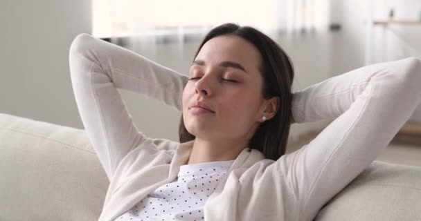 Mindful young beautiful woman meditating or daydreaming on comfortable sofa. — Stock video