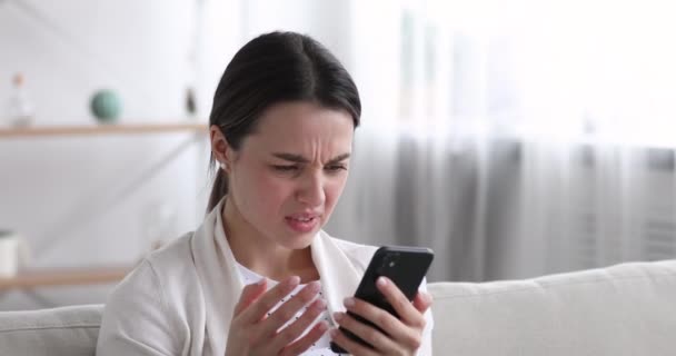 Displeased young woman got spam or scam sms. — Stock video