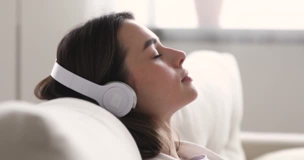 Mujer feliz y pacífica escuchando música clásica tranquila en los auriculares . — Vídeos de Stock
