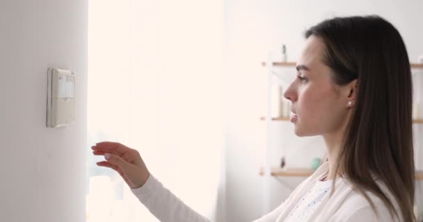 Feliz joven mujer activando el sistema de alarmas de apartamentos antes de salir de casa . — Vídeo de stock