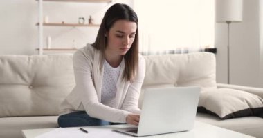 Evde bilgisayarla çalışan ciddi meşgul genç bir iş kadını..