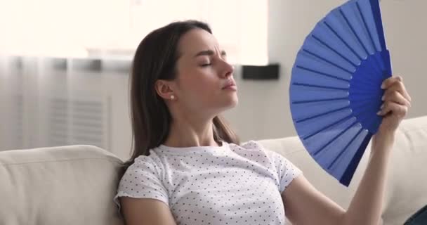 Överhettad ung vacker kvinna som lider av hög temperatur inomhus. — Stockvideo