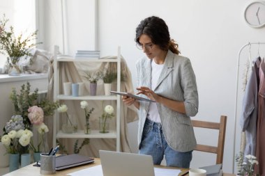 Kendine güvenen beyaz iş kadını evde aletler üzerinde çalışıyor.
