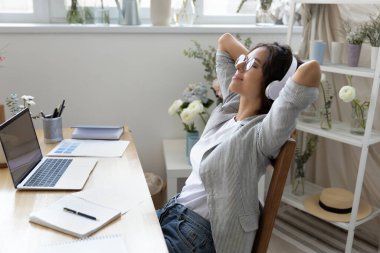 Genç bayan işyerinde rahatla kulaklıkla müzik dinle.