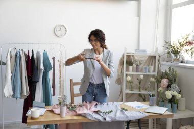 Beyaz kadın tasarımcı. Akıllı telefondaki fotoğraf elbiseleri.