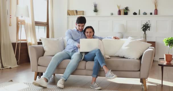 애정어린 유대 관계를 맺고 있는 남녀는 컴퓨터를 사용하여 소파에서 긴장을 풀고 있다. — 비디오