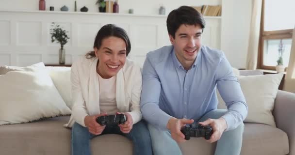 Überglückliches junges Familienpaar feiert Sieg im Videospiel. — Stockvideo