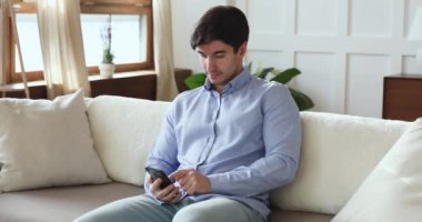 Mobil sosyal ağ uygulaması kullanan mutlu genç adam.