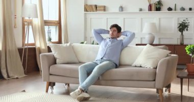 Huzurlu genç adam rahat bir kanepede uyuyor.