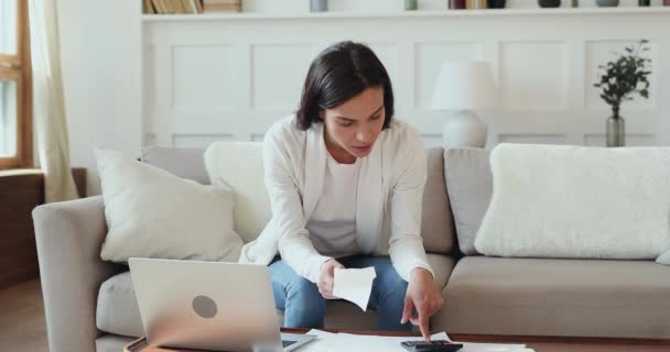 Konzentrierte junge Frau plant allein im Haus Investitionen. — Stockvideo