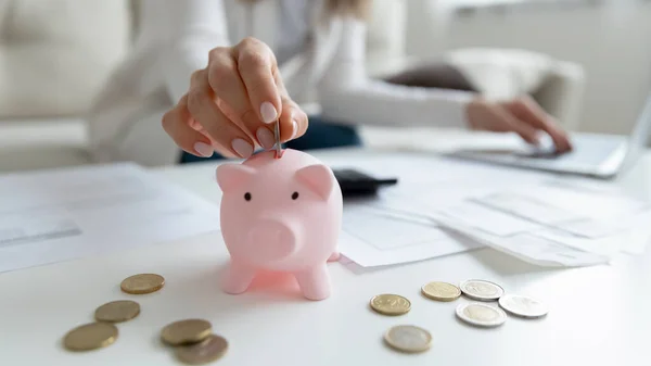 Vrouwelijke hand maken persoonlijke besparingen zet munt in spaarvarken bank — Stockfoto
