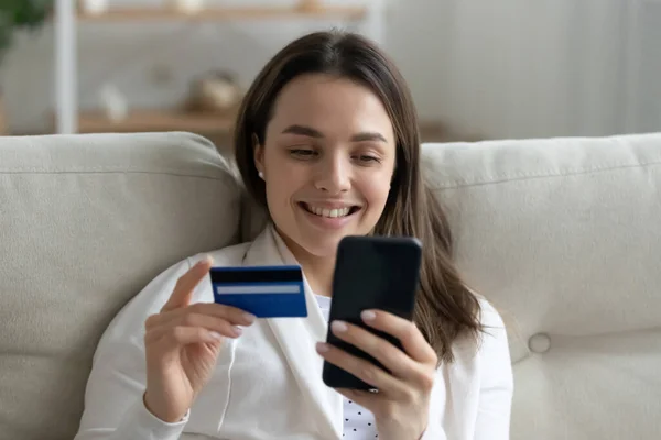 Mujer comprando en internet pagando con tarjeta de crédito y teléfono inteligente — Foto de Stock