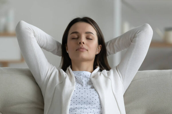 Peaceful woman closed eyes enjoy fresh air relaxing at home