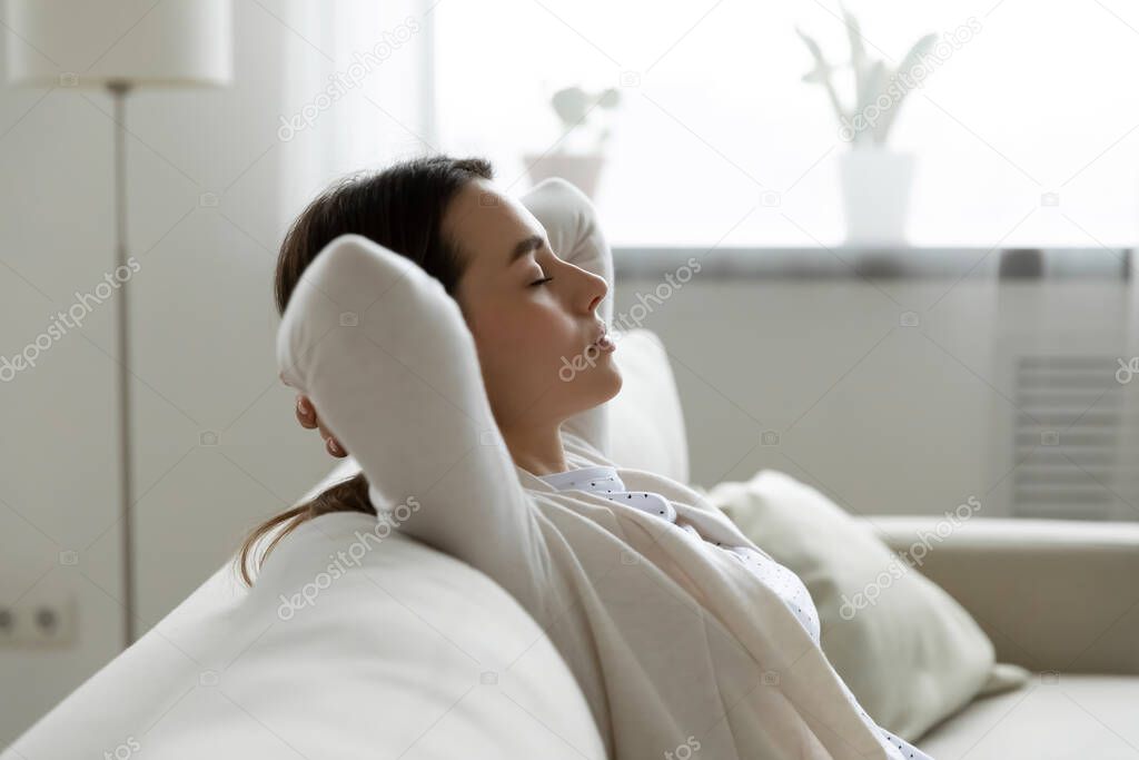 Calm woman closed eyes enjoy fresh air relaxing at home