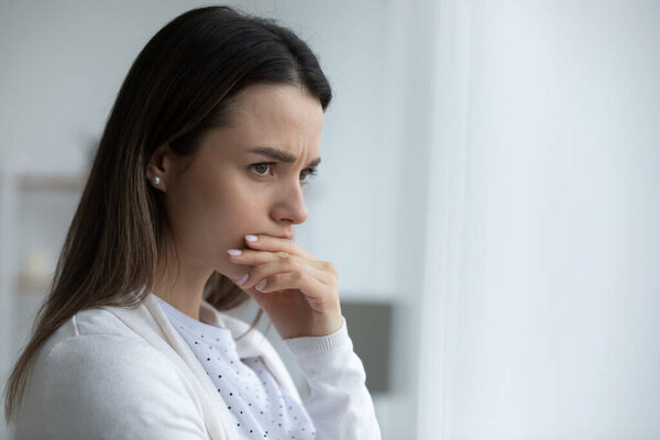 Woman looking in distance feels upset having life troubles