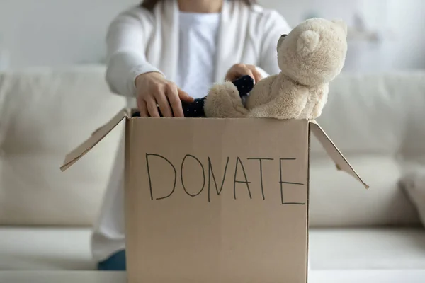 Vrouw zet gebruikte kleren in donatie doos closeup conceptuele afbeelding — Stockfoto