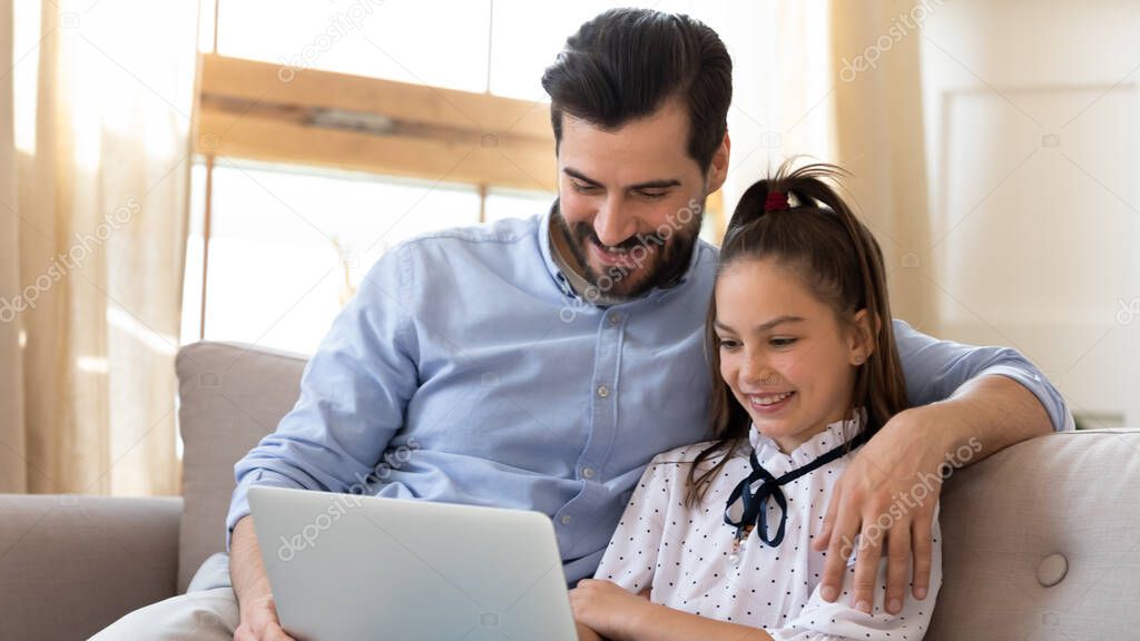 Happy father with daughter using laptop together at home