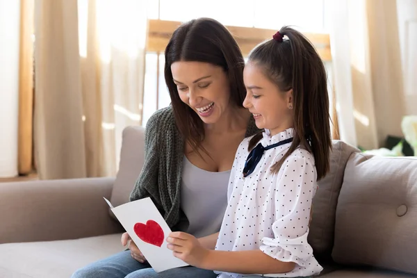 Kleine dochter presenteren wenskaart aan gelukkige moeder — Stockfoto