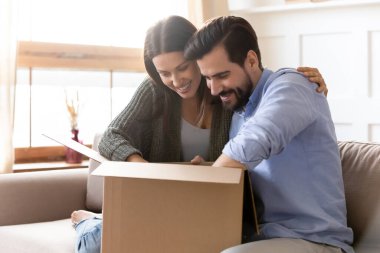 Karton paket paketini açan meraklı genç çift.