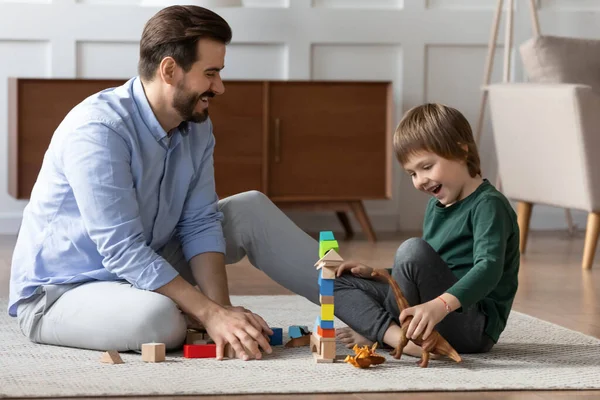 Pai feliz e filho pequeno brincando com brinquedos juntos — Fotografia de Stock