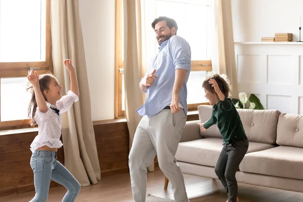 Boldog apa fiával és lányával táncol a nappaliban — Stock Fotó