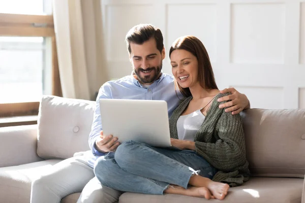 Щаслива молода пара використовує ноутбук разом, дивлячись на екран — стокове фото