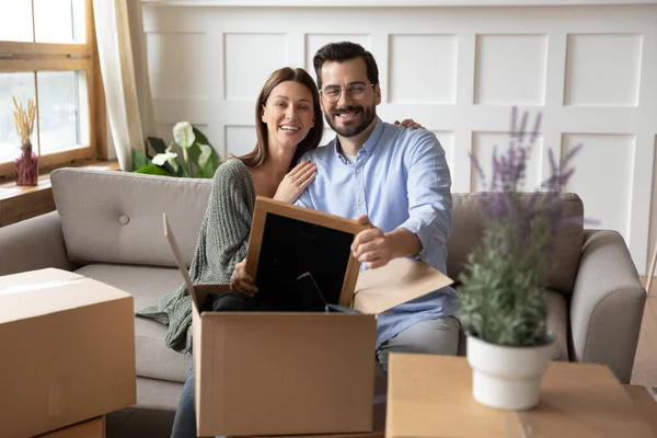 Retrato familia feliz sentado en el sofá, mudarse a una casa nueva — Foto de Stock