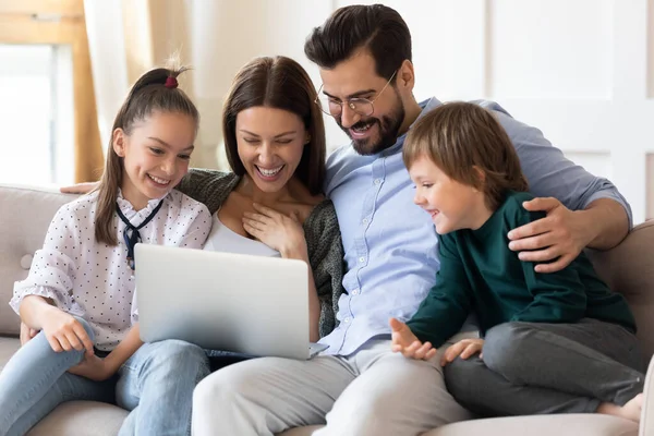 Família feliz se divertindo com laptop em casa juntos — Fotografia de Stock
