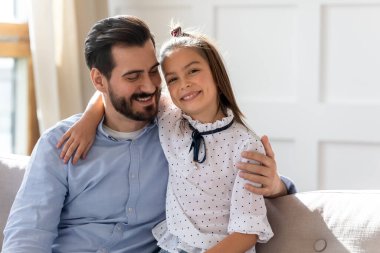 Sevgili babasıyla kucaklaşan sevimli bir kızın portresi.
