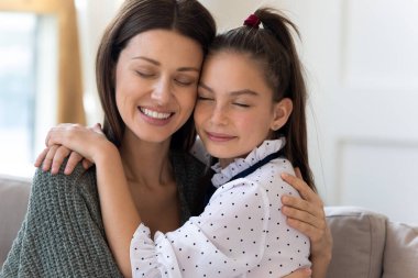 Gülümseyen anne ve küçük kız şefkatli anın tadını çıkarıyorlar.