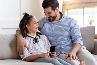 Mutlu baba ve kız akıllı telefonla eğleniyorlar.