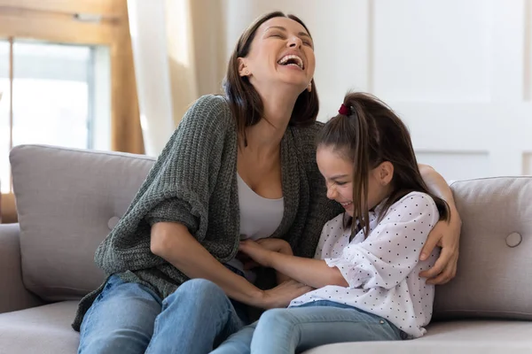 Glückliche Mutter kitzelt entzückende Tochter, spielt lustiges Spiel zu Hause — Stockfoto