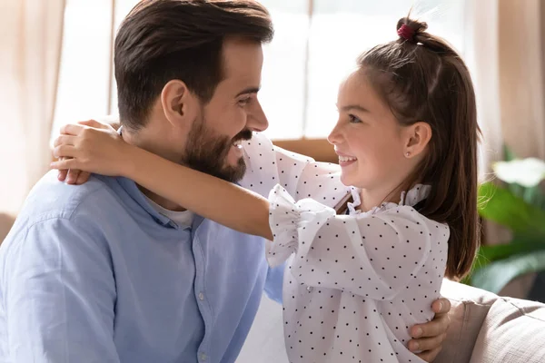 Крупным планом улыбающиеся отец и дочь обнимаются, глядя в глаза — стоковое фото