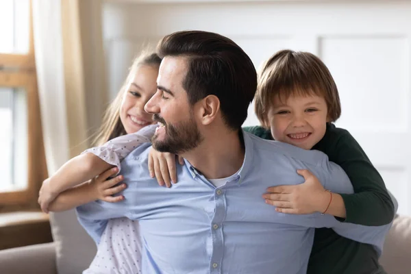 Head shot portrait happy father hugging adorable little children