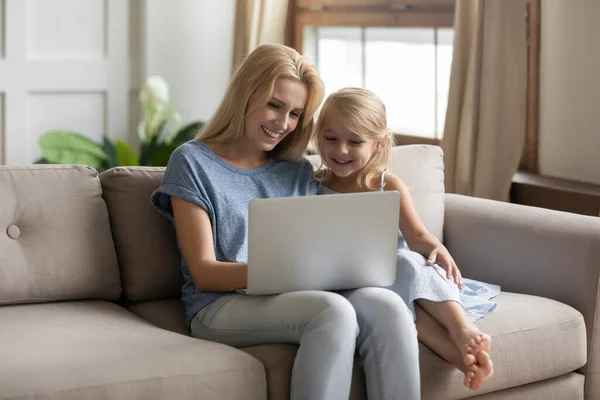 Mutter und kleine Tochter schauen Bildungsprogramm mit Laptop — Stockfoto